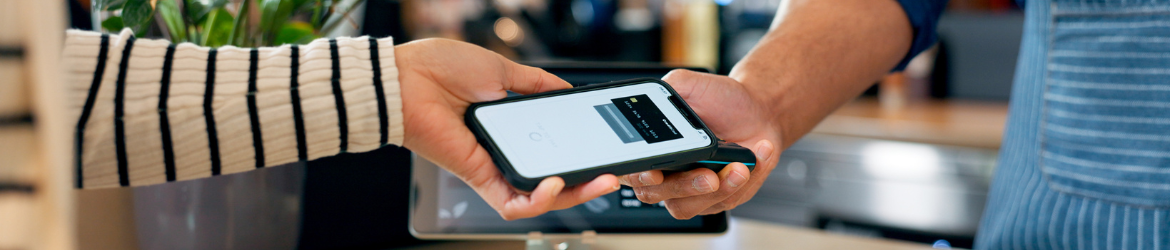 Hand holding phone to pay using digital wallet.