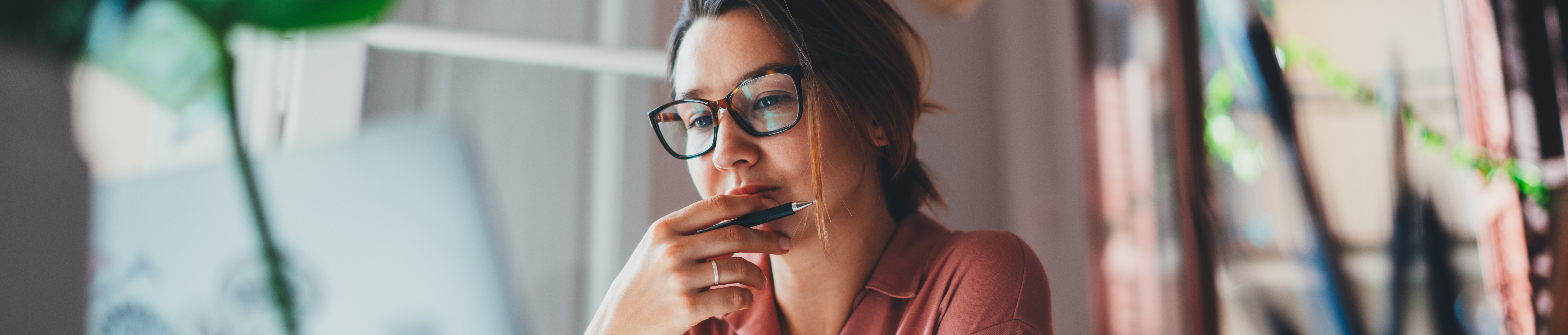 Young woman in thought while looking at laptop.