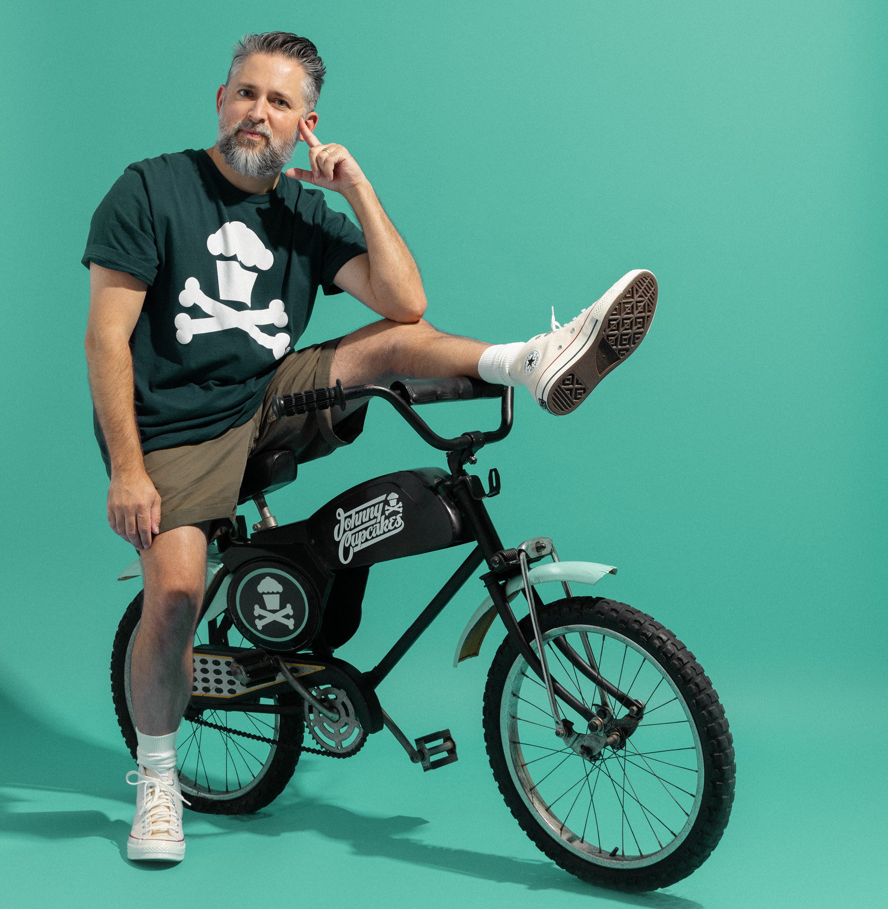 Johnny Cupcakes sitting on a bike
