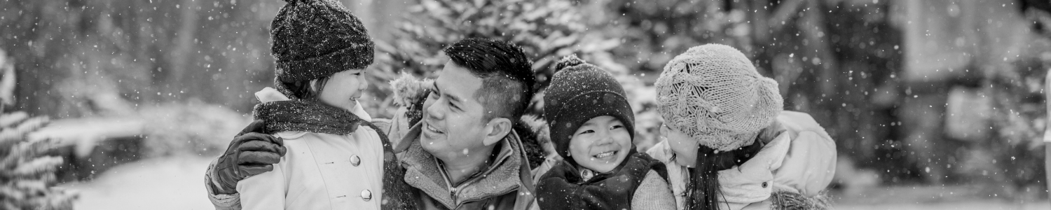 Family huddled together while snow is falling.